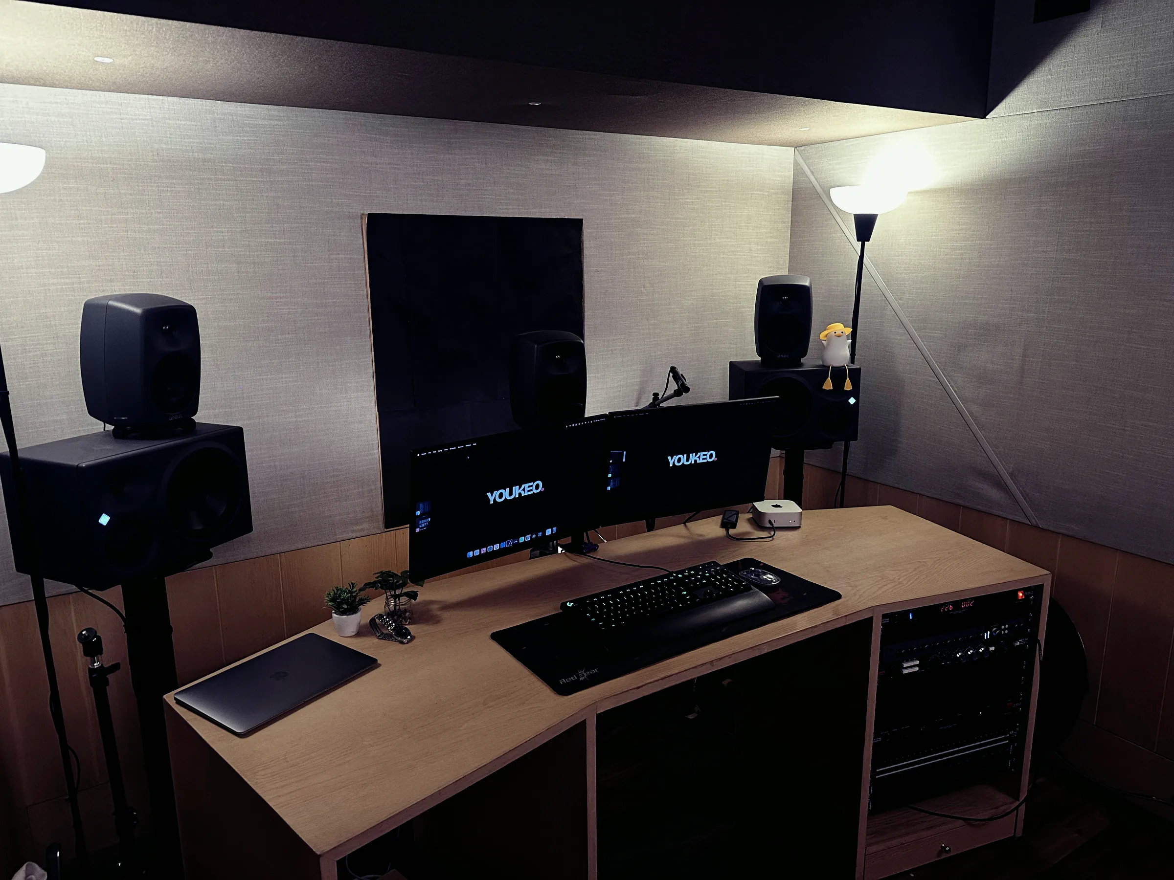 Control room desk with two screens between Neumann and Genelec monitors